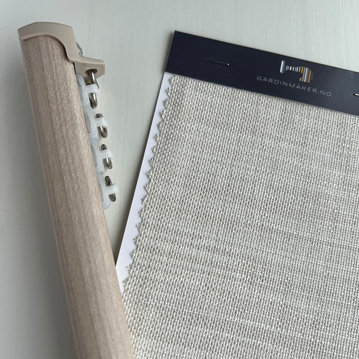 Detaljbilde av Toso Nexty gardinskinne i Grå ask med trinser på hjul og tekstilprøve Cosia i fargen Parchment fra Gardinmaker.no. Foto.